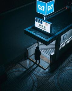 a person standing in front of a bus stop with a sign on it's side