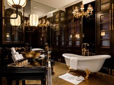 a bathroom with a claw foot tub and chandelier