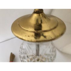 a gold colored light fixture on top of a white wall next to a toothbrush