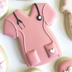 decorated cookies with pink icing and stethoscopes on white tablecloth