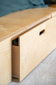 a close up of a wooden drawer on a bed