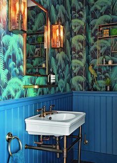 a bathroom with blue walls and green plants on the wall