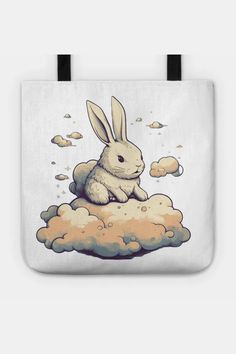 a white tote bag with an image of a rabbit sitting on top of clouds