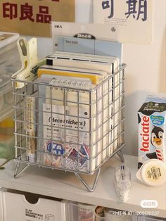 a metal basket filled with files and folders on top of a shelf next to other office supplies