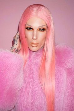 a woman with pink hair and piercings on her head is wearing a fur coat