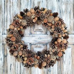 a wreath made out of pine cones and acorns on a wooden door frame