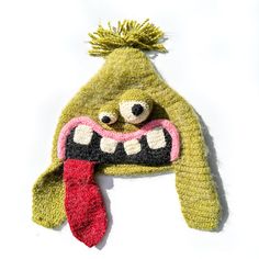 a knitted hat with a monster's mouth and tongue sticking out from it