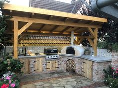 an outdoor kitchen is built into the side of a brick wall and covered in wood