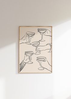 a painting hanging on the wall with two hands holding wine glasses