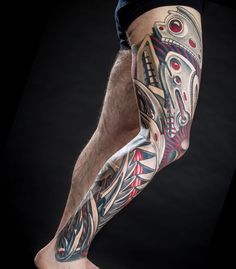 a man's leg with tattoos on it