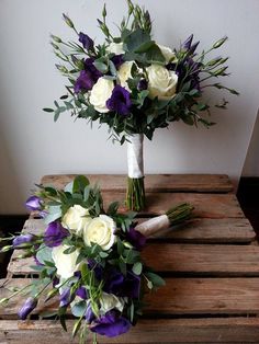 two bouquets of flowers sitting on top of a wooden table next to each other