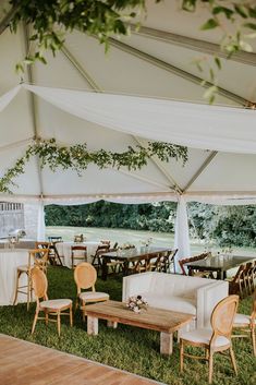 the inside of a tent with tables and chairs set up for an outdoor wedding reception