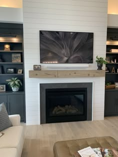 a large flat screen tv mounted on the wall above a fireplace in a living room