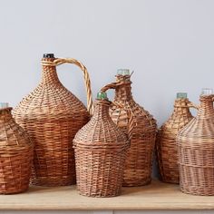 wicker jugs and baskets are lined up on a shelf