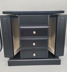 a small black cabinet with three drawers