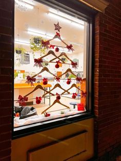 a christmas tree made out of wooden sticks is displayed in a store's window