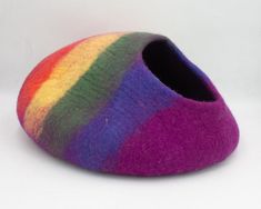 a multicolored slipper is sitting on a white surface and it's made out of wool