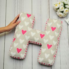 the letter h is made out of fabric with pink and white heart shapes on it