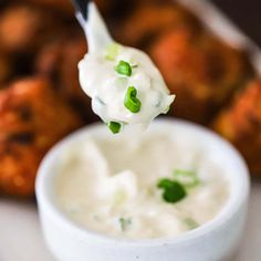 a spoon full of sour cream and green onions