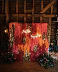 an orange and red backdrop with the word brother together written on it, surrounded by greenery