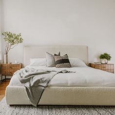 a white bed sitting in a bedroom next to a window