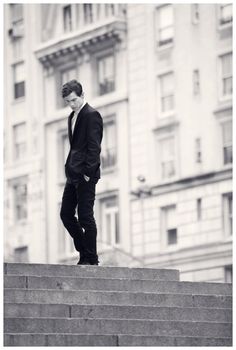 a man in a suit is standing on some steps