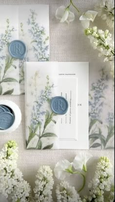 wedding stationery with flowers and wax stamp on it, including the monogrammed seal