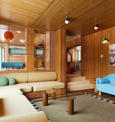 a living room filled with lots of furniture and wooden paneled walls on either side of the couches