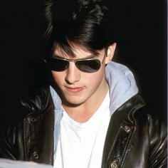 a young man wearing sunglasses and a leather jacket