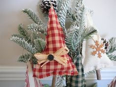 a christmas tree decorated with red and white plaid fabric, pine cones and burlocks