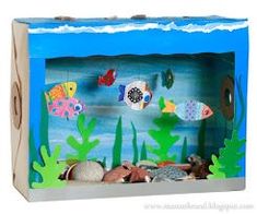 an aquarium with fish and seaweed on the bottom is shown in this cardboard box