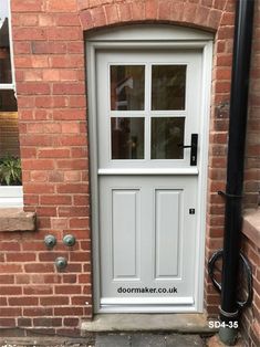 an image of a white front door on a brick house with glass paned windows