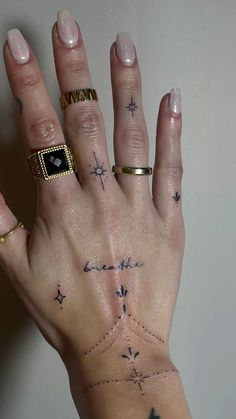 a woman's hand with tattoos on her left and right palm, which is holding a diamond ring