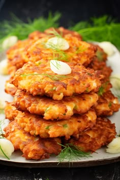 some crab cakes are stacked on a plate