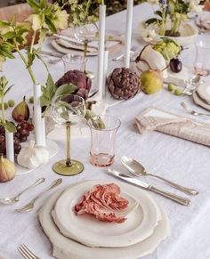 a table set with white plates and silverware