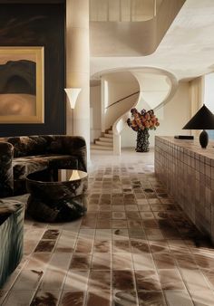 a living room filled with furniture next to a spiral stair case and painting on the wall