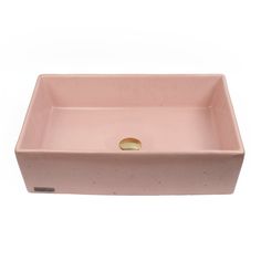 a pink square sink with a gold faucet in the middle and a white background