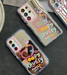 two cell phones with happy birthday designs on them sitting next to some other phone cases