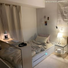 a small bedroom with a bed, desk and lamp