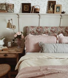 a bed with pink and white comforter in a bedroom next to a wooden table