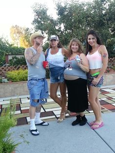 three women and one man posing for the camera