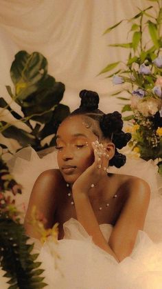 a woman in a wedding dress with flowers on her head and hands to her face