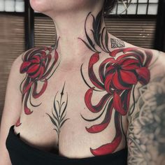 a woman with red flowers on her chest and shoulder tattoo design in front of her