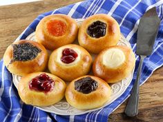 small pastries with jams and jelly on a white plate next to a blue towel