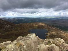 a view from the top of a mountain looking down at a lake