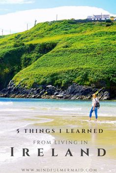 a woman standing on top of a sandy beach next to green grass covered hills and the words, things i learned from living in ireland