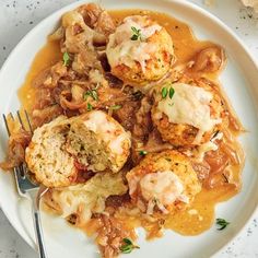 a white plate topped with meatballs covered in gravy