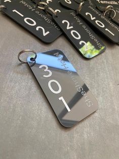 four black and blue tags with numbers on them sitting on a gray table next to each other