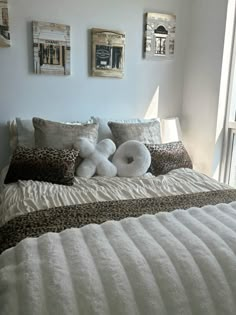 a bed with white pillows and leopard print on it