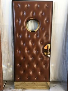 a brown door with an oval hole in the middle